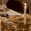 Mesa decorada de navidad con textiles blancos, velas y vajilla elegante