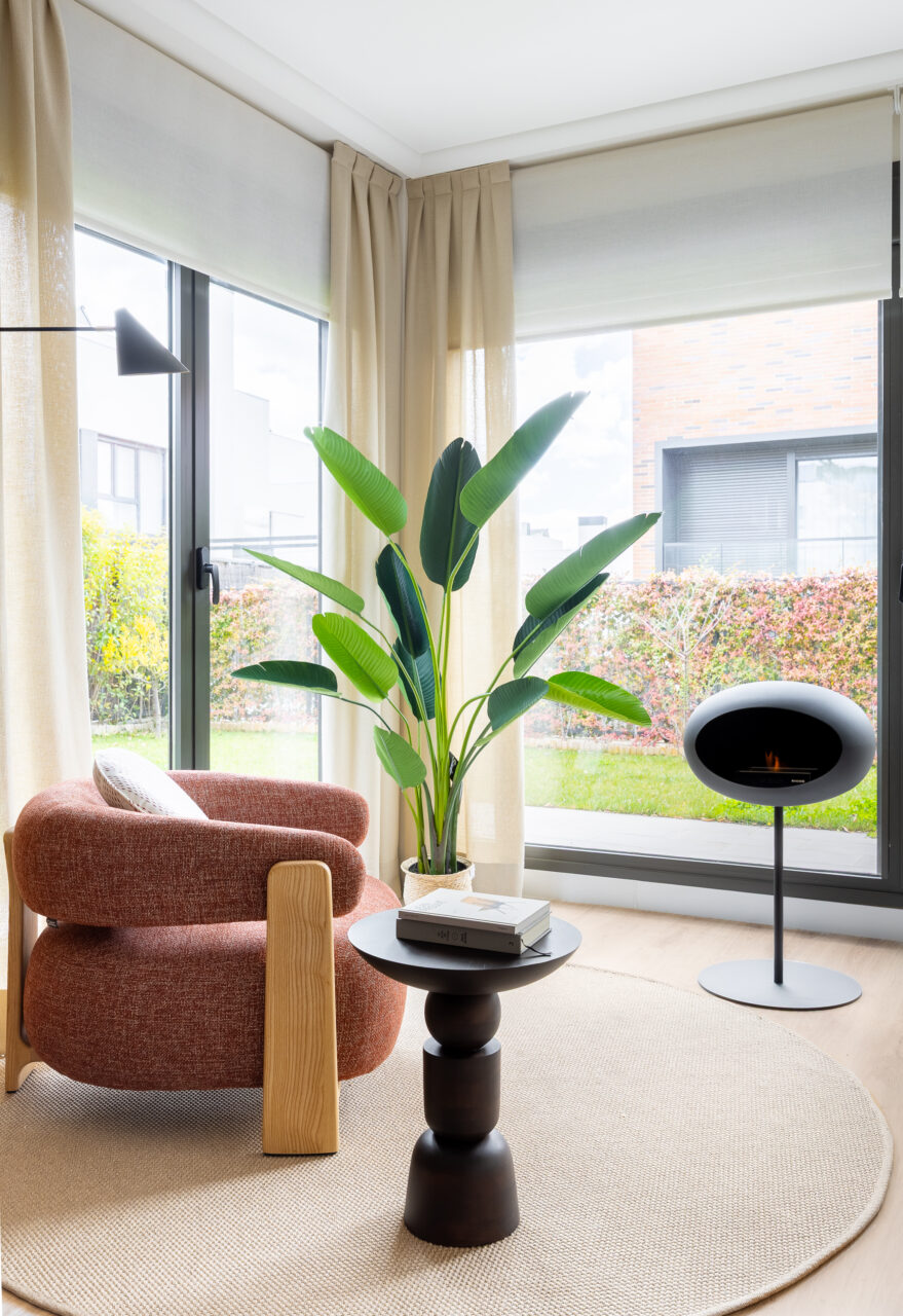 Rincón de lectura y chimenea en vivienda de Colmenar Vieja con interiorismo de María del Valle.